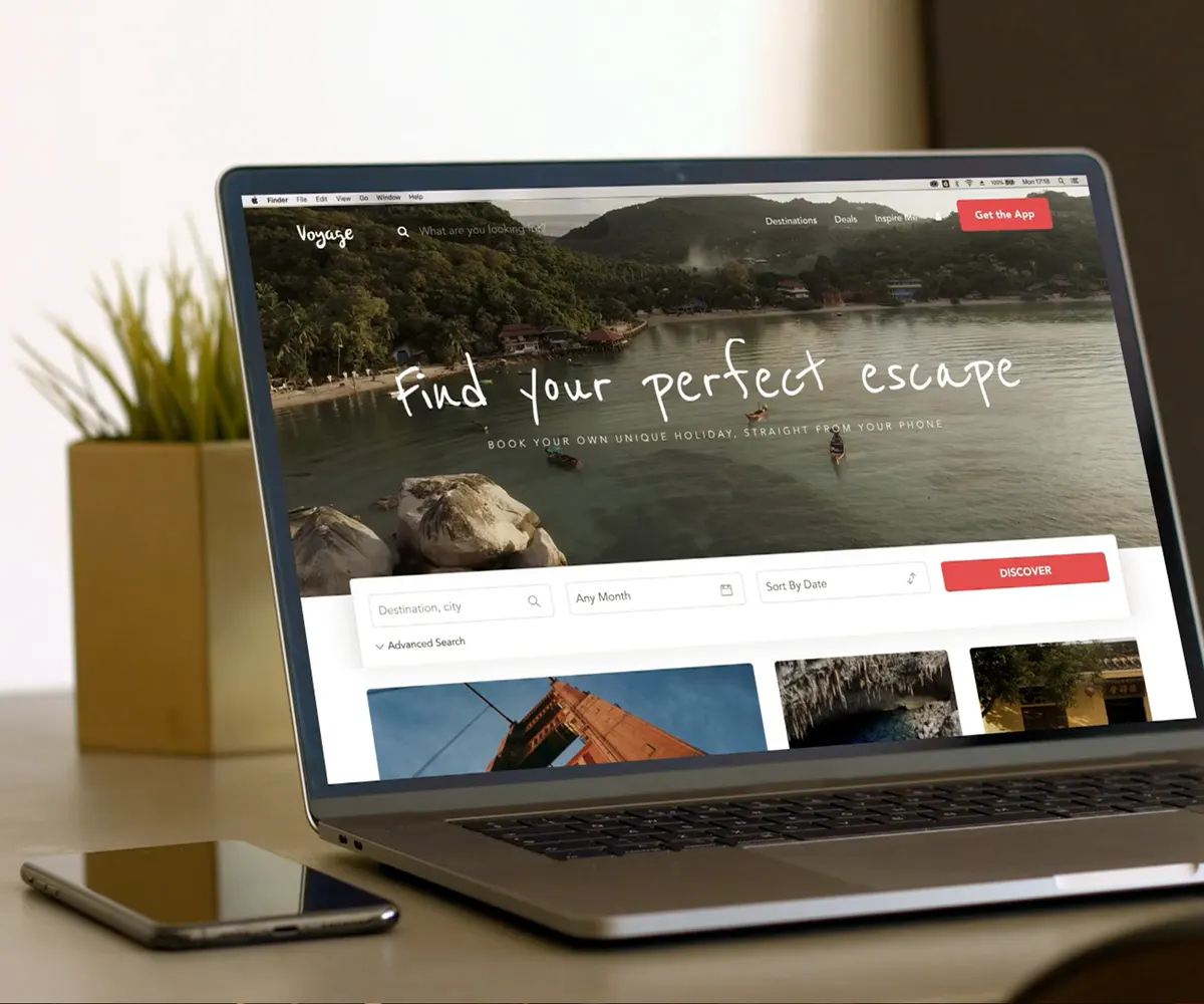 The Voyage Travel website on a laptop